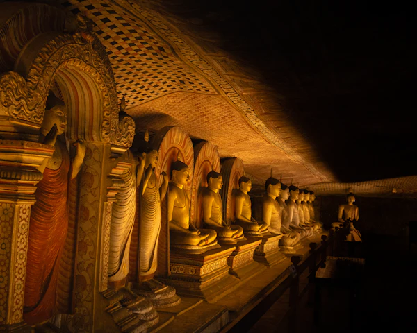 Rows of golden Buddha statues lining a painted cave temple