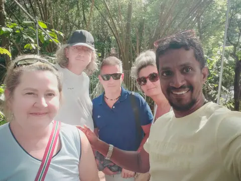 Four guests and their driver-guide taking a selfie among tall bamboo