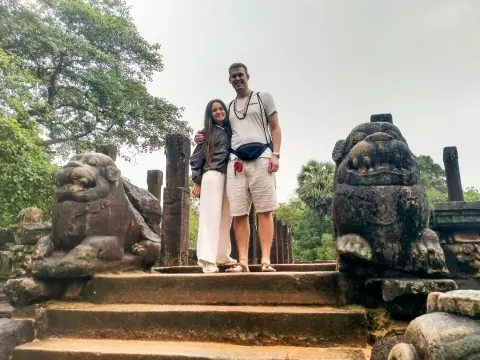 Two guests standing between carved stone lions at the top of a flight of ancient steps