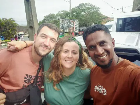 Two guests and their driver-guide taking a selfie at a roadside stop