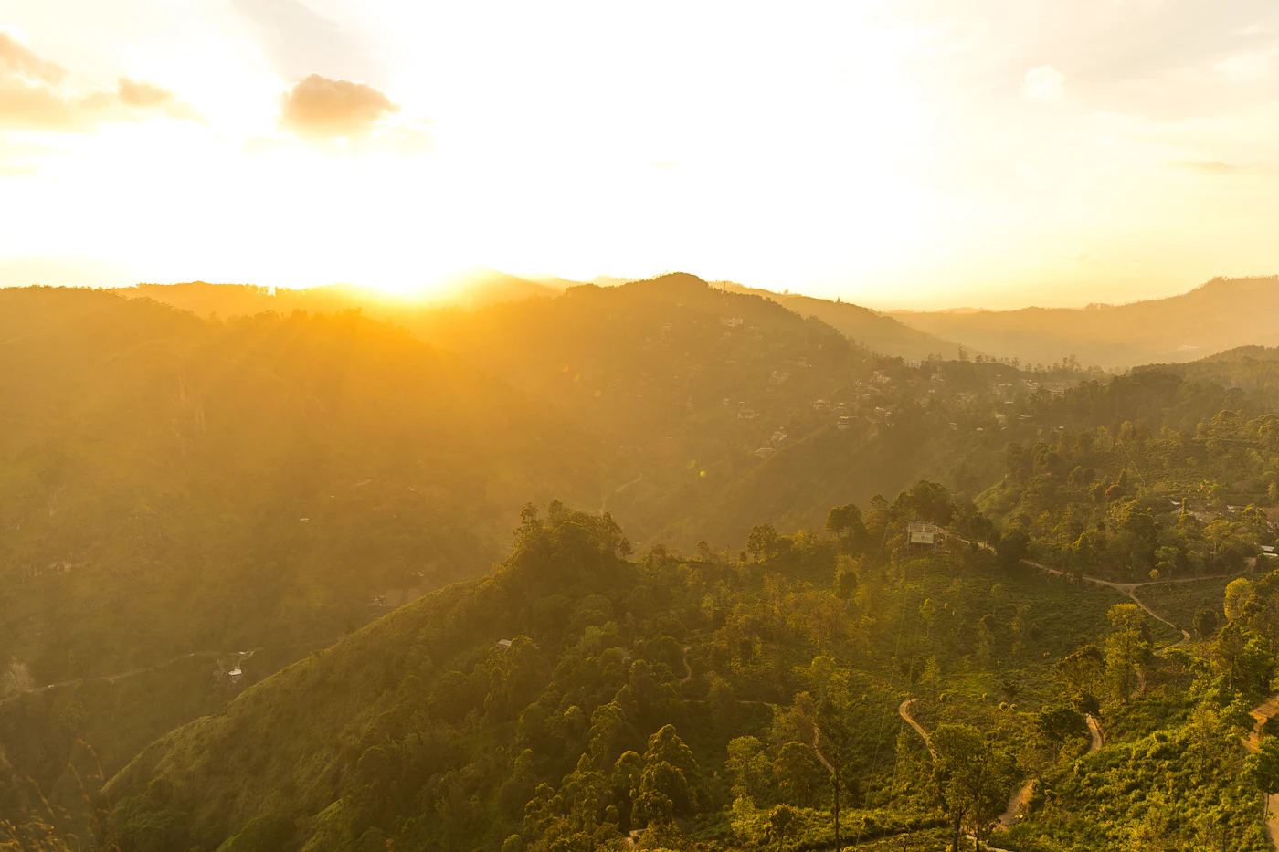Golden sunrise light over layers of forested hills near Ella